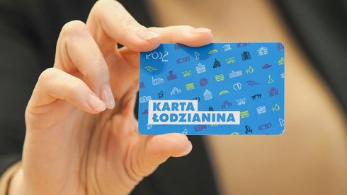 Damska dłoń trzymająca niebieską kartę z napisem "Karta Łodzianina".