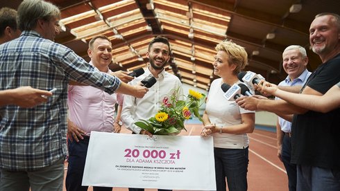 Adam Kszczot zdobył złoty medal za pierwsze miejsce w biegu na 800 m. Za to osiągnięcie odebrał symboliczny czek na 20 tys. zł. fot. Radosław Jóźwiak / UMŁ